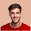Smiling young man with short brown hair wearing a red shirt against a beige background.