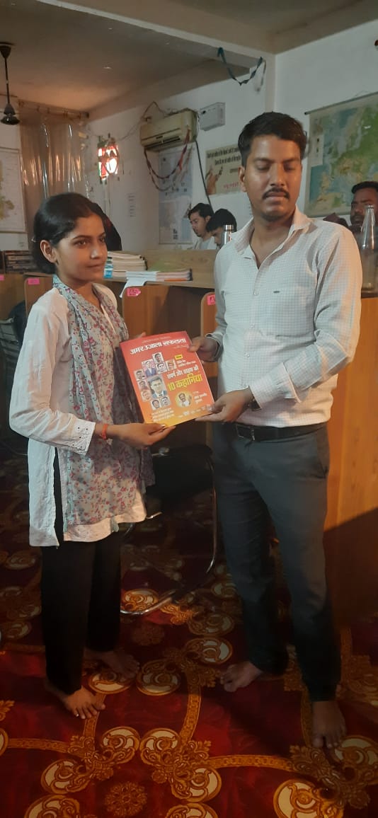 Children receiving books from PFMECT volunteers