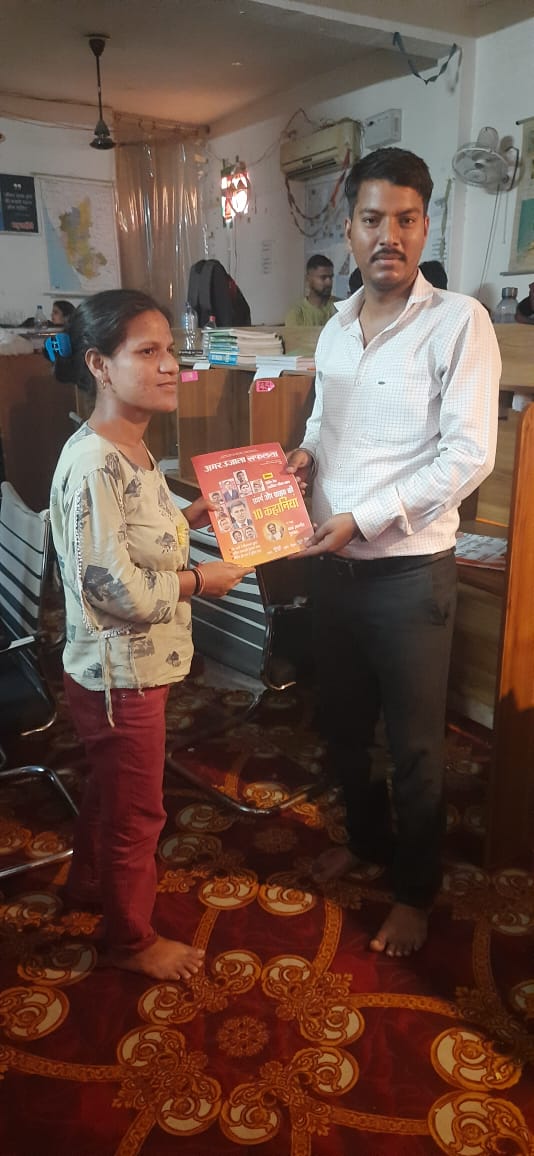 PFMECT volunteers distributing books to students
